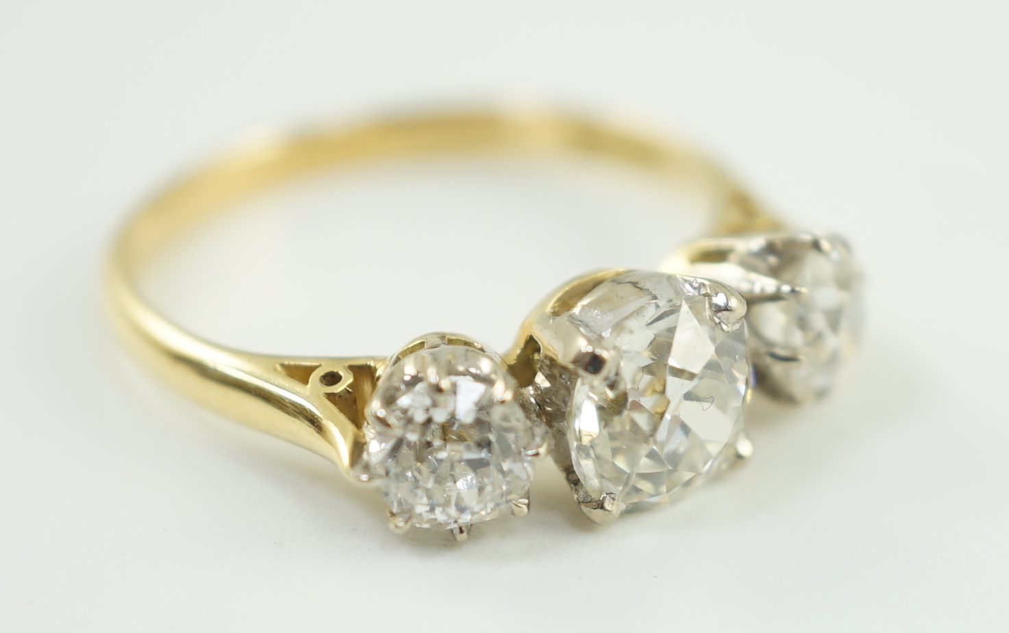 A modern 18ct gold and three stone diamond set ring